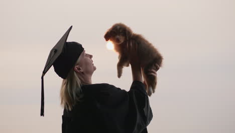 A-Woman-In-A-Graduate-Costume-Holds-A-Cute-Puppy-In-Her-Arms-College-Graduation-Gift