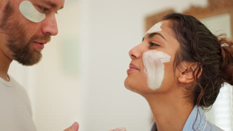 pareja, cuidado de la piel y máscara facial en el baño de la casa