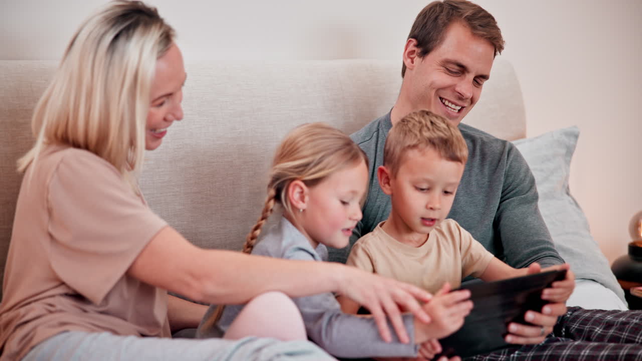 Genitori, bambini e tablet in camera da letto per i giochi