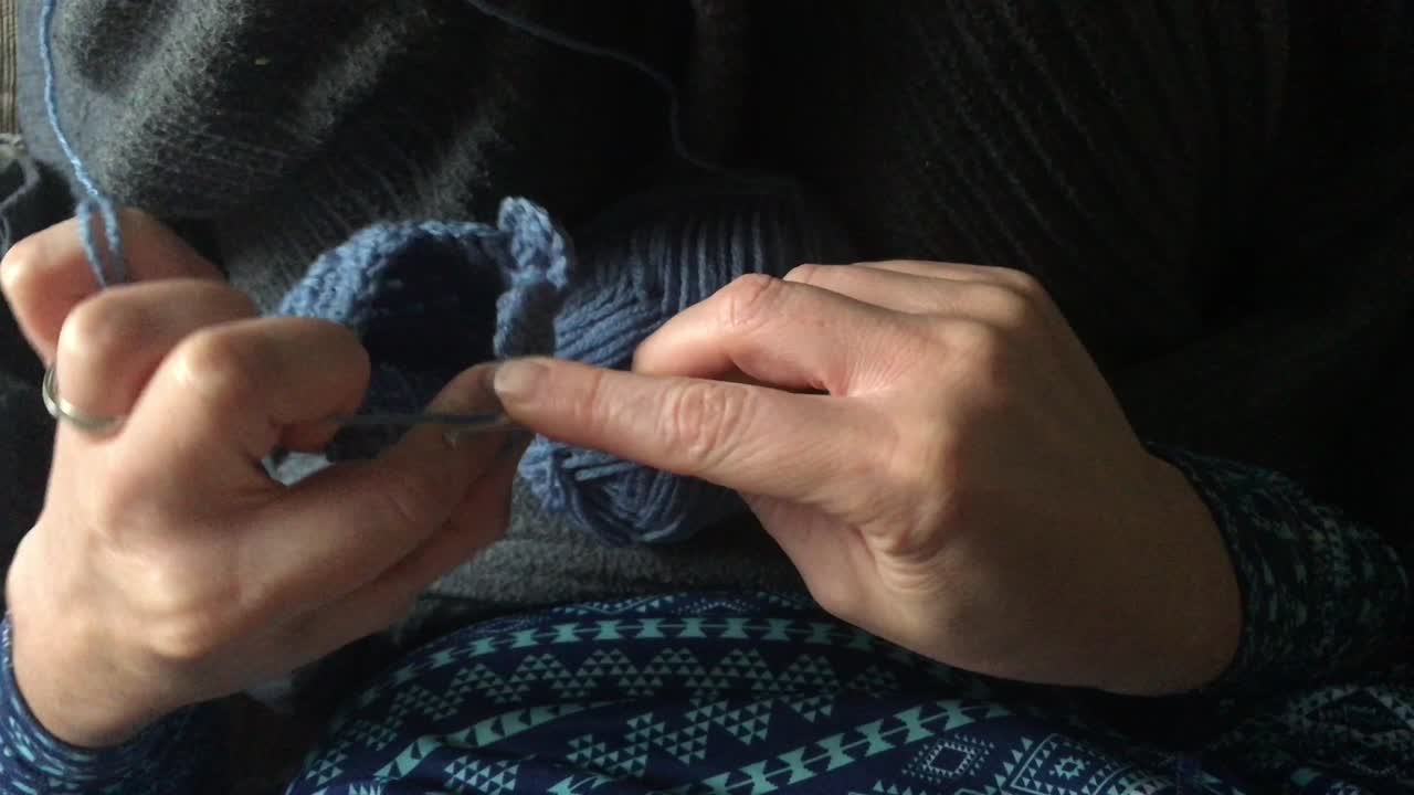 mujer ganchando una pequeña bolsa azul en