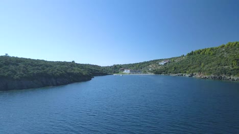 Cinematic-forward-moving-towards-some-villas-4K-drone-clip-over-the-tropical-blue-waters-of-Toroni-in-Chalkidiki