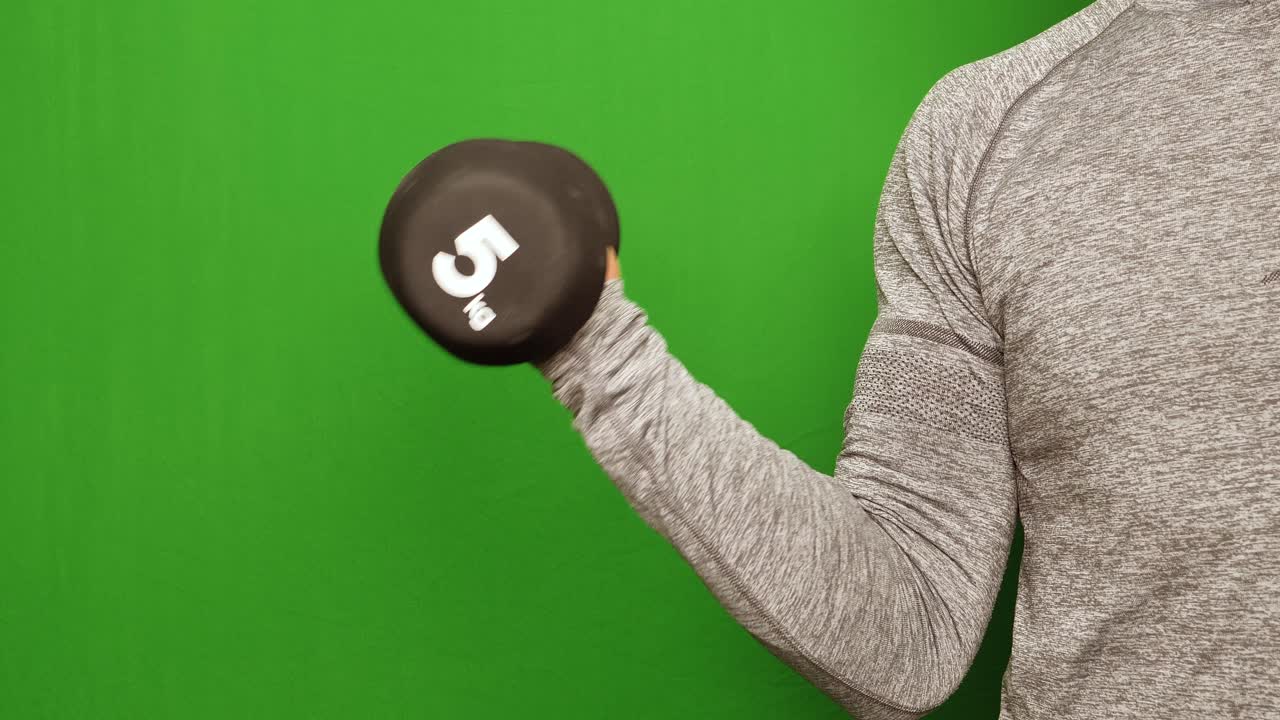 운동선수 남성은 녹색 화면에서 검정색 5kg 아령으로 이두근을 훈련합니다.