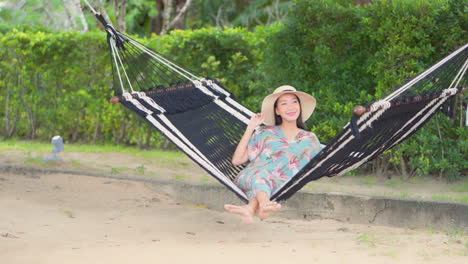 Una-Mujer-Joven-Y-Bonita-Se-Balancea-Tranquilamente-En-Una-Hamaca-Suspendida-Sobre-Una-Playa-De-Arena