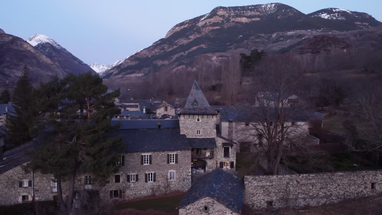 스페인의 산꼭대기와 전통적인 돌집 사이에 자리잡은 역사적인 피레네 마을인 안실레스 (ancilies) 에서 해가 지는 색 - 공중