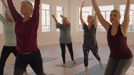 Yoga-Kurs-Von-Gesunden,-Reifen-Frauen,-Die-Kriegerpose-Praktizieren-Und-Morgens-Körperliche-Fitnessübungen-Im-Studio-Bei-Sonnenaufgang-Genießen