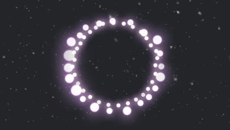 animation of circle of glowing round pink christmas fairy lights over falling snow, on black