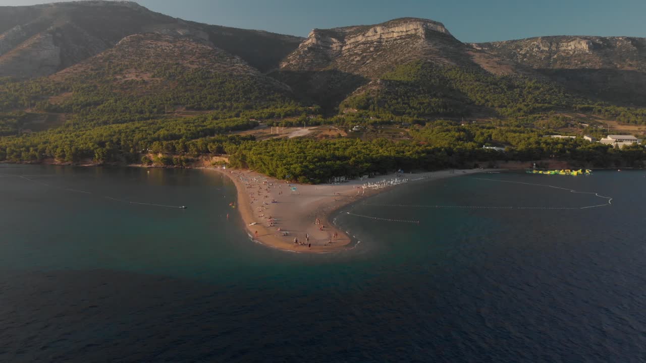 Aerial shot pulling away to reveal the famous Zlatni Rat beach on the island of Brac in Croatia