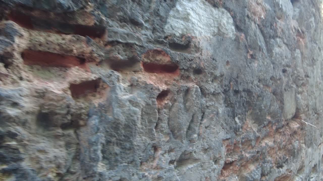 눈에 띄는 손상으로 오래된 벽돌과 돌 벽의 근접 시각.