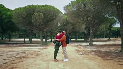 romantic couple hugging forest path feeling happiness vertical. hikers relaxing.