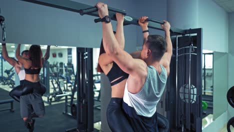Couple exercising together at gym. Fit woman working out with trainer at the gym