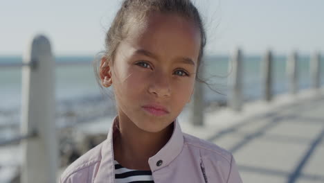 portrait young little mixed race girl looking serious contemplative kid on sunny seaside beach slow motion