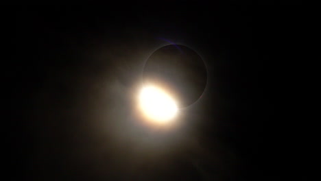 un largo efecto de anillo de diamante con rayos de luz solar que fluyen a través de nubes ligeras durante el eclipse solar total del 8 de abril de 2024