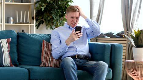 middle aged man upset for loss while using smartphone