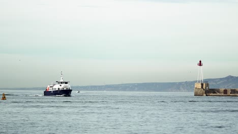 Ferry-boat-entering-the-port-of-Marseille-in-France-with-light-beacon,-Wide-view-from-floating-vessel