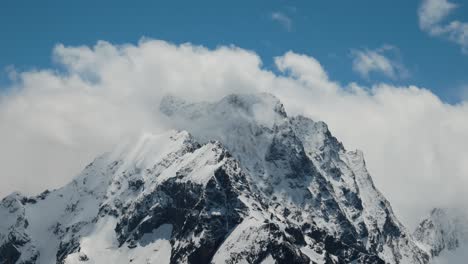 vuelo aéreo a través de nubes montañosas sobre hermosos picos nevados de montañas y glaciares.