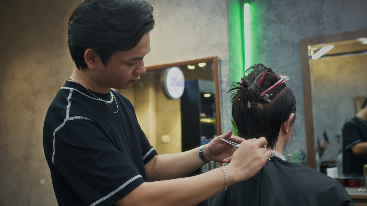 Frisør klipper hår i en barbersalon