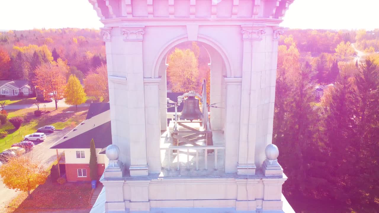Drone spiral ascent over a church amidst an autumnal scene in a Canadian village