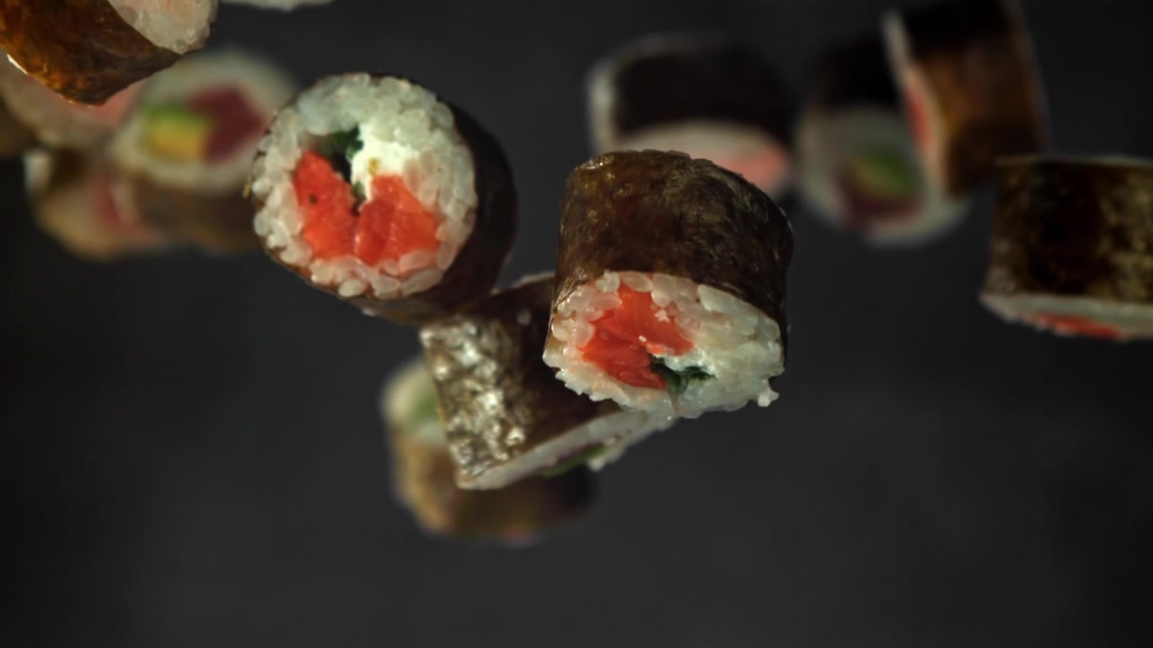 Sushi Maki assortiti che fluttuano e cadono al rallentatore