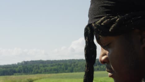 Samson-holding-grain-in-hand-while-looking-at-surrounding-green-landscape,-Biblical-character-with-long-dreads,-Israelite-warrior-and-judge,-black-male-in-old-testament,-Christian