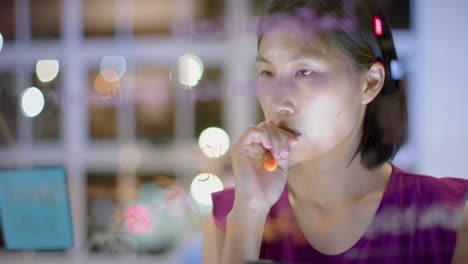 asian casual businesswoman using tablet brainstorming, making notes on glass wall at night in office