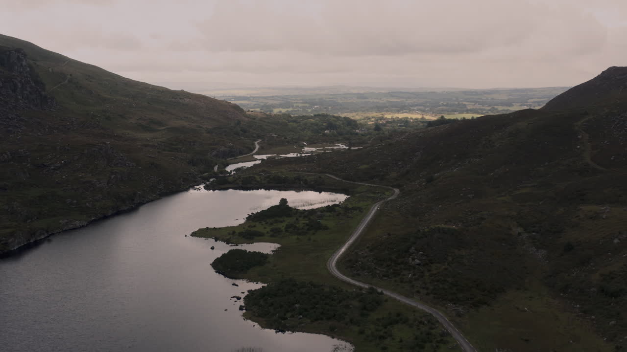 Aerial view of a scenic Irish valley with a lake and winding road