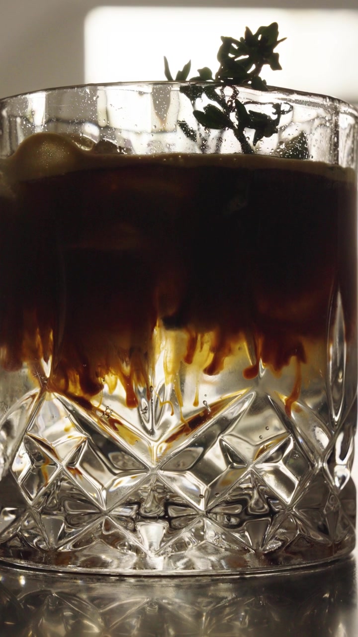 Primo piano verticale di gin tonic all'espresso in un bicchiere trasparente, Repubblica Ceca.