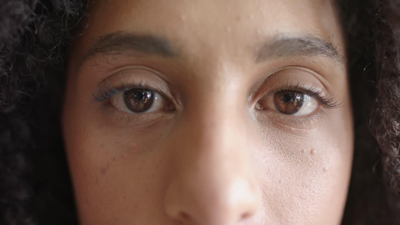 un retrato de cerca de los ojos de una feliz mujer de negocios biracial en cámara lenta.