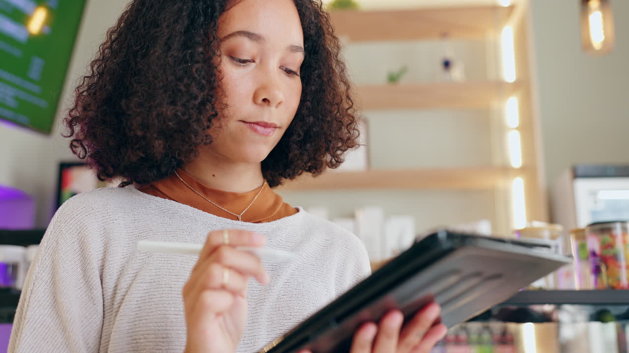 Woman thinking in cafe with tablet and pencil