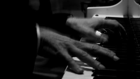 man playing the piano in black and white