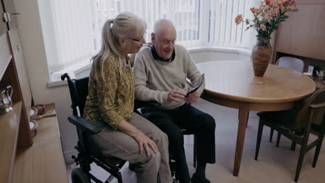 elderly man using tablet with caregiver at home