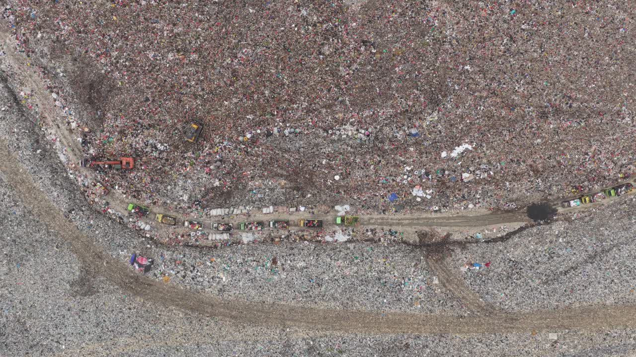 Vista aerea di camion della spazzatura in un enorme sito di discarica a Bali
