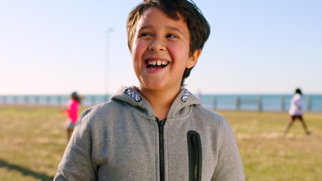 Smile,-grass-and-portrait-of-child-at-beach-having