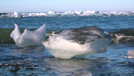 los icebergs se sientan en la playa de diamantes de arena negra jokulsarlon en el ártico islandia pulidos y relucientes como joyas
