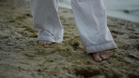 Unbekannter-Barfüßiger-Mann,-Der-In-Nahaufnahme-Auf-Den-Strand-Tritt.-Sportler-Trainiert-Am-Meeresufer