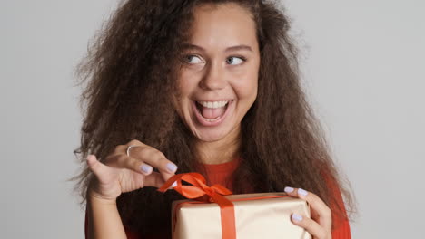 happy caucasian curly haired woman with a present.