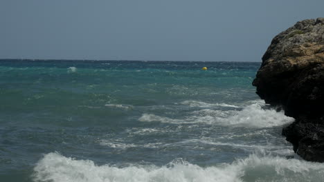 High-waves-from-the-Mediterranean-sea-on-Mallorca-hit-the-stones-and-rocks-on-the-coast-on-a-sunny-day