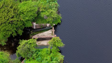 Dam spillway of reservoir drops controlling flow of water into river from tropical holding area