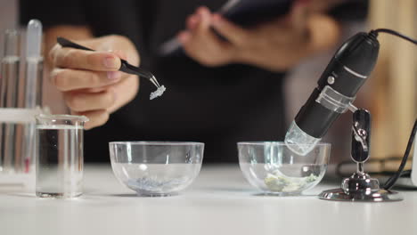 man examines crystalline substance piece in classroom lab