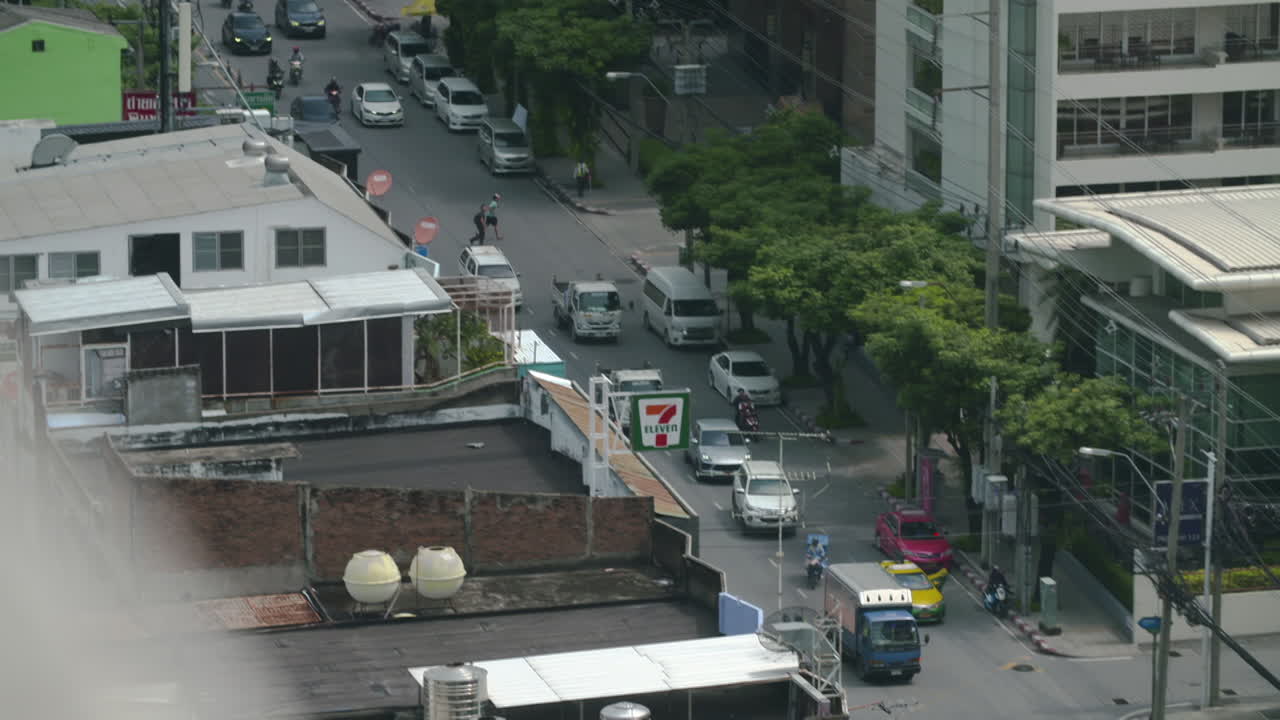 Cars and TukTuk driving along Thonglor Street in Bangkok at daytime, Top Shot