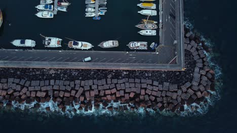 Top-down-aerial-view-of-breakwater-of-yacht-harbor-in-Tenerife,-static
