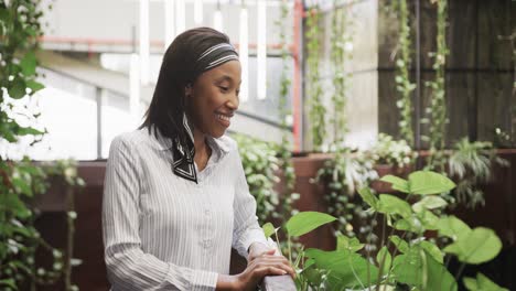 Portrait-of-african-american-casual-businesswoman-standing-in-office-foyer-smiling,-slow-motion