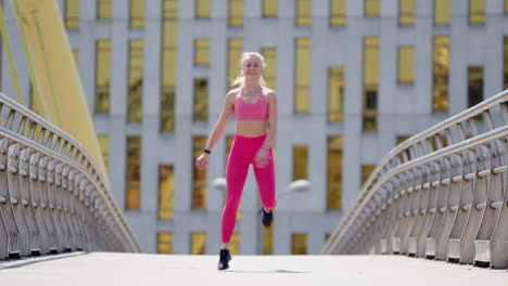 smiling fit young blonde woman exercises on bridge, wide frontal view