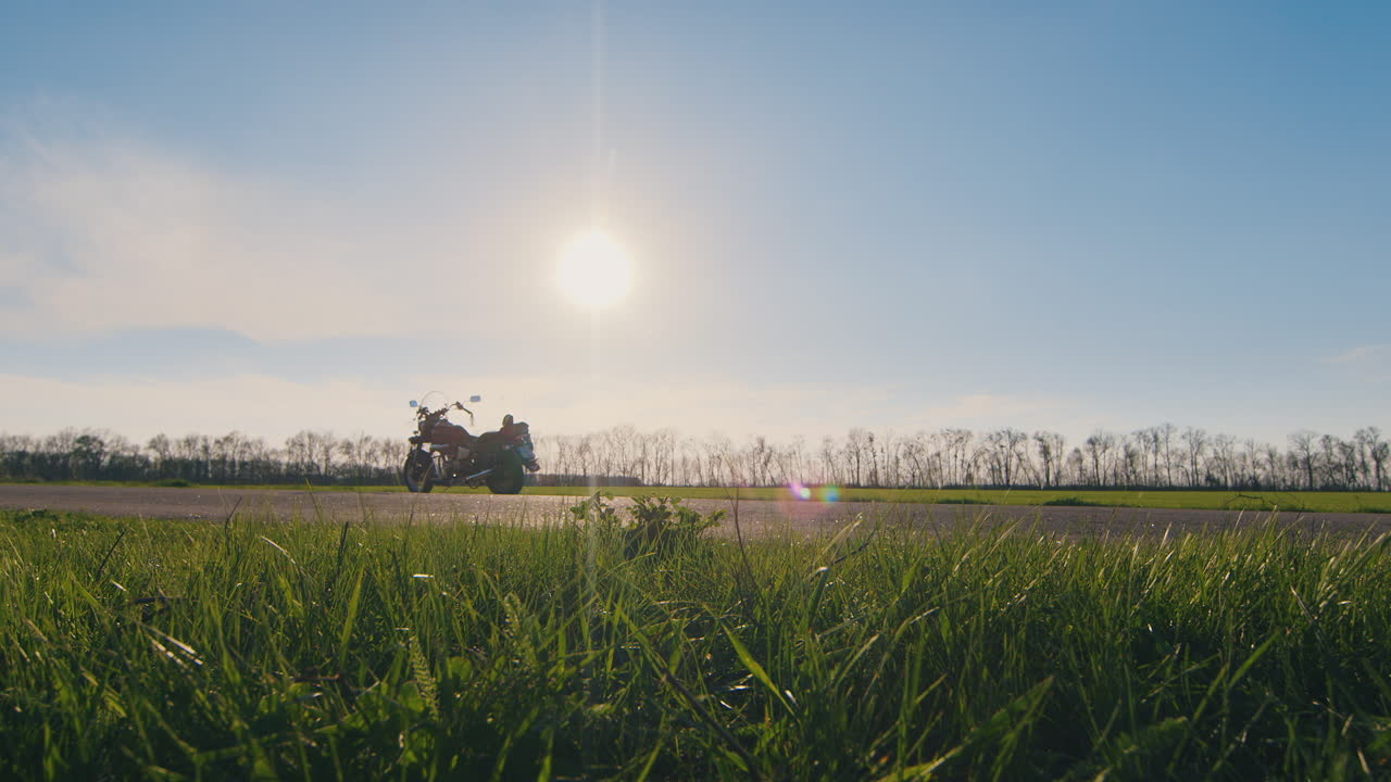헬멧을 손에 들고 오토바이 hd 비디오를 보고 있는 바이커의 실루엣