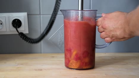 Nahaufnahme-Einer-Männlichen-Hand,-Die-Tomaten-In-Einem-Mixer-Zerkleinert,-Um-Frische-Hausgemachte-Tomatensauce-Zum-Kochen-Von-Pizza-Im-Italienischen-Stil-Zuzubereiten