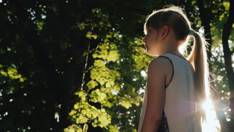 the child stands in the beam the sun is shining on her face get lost in a fairy forest