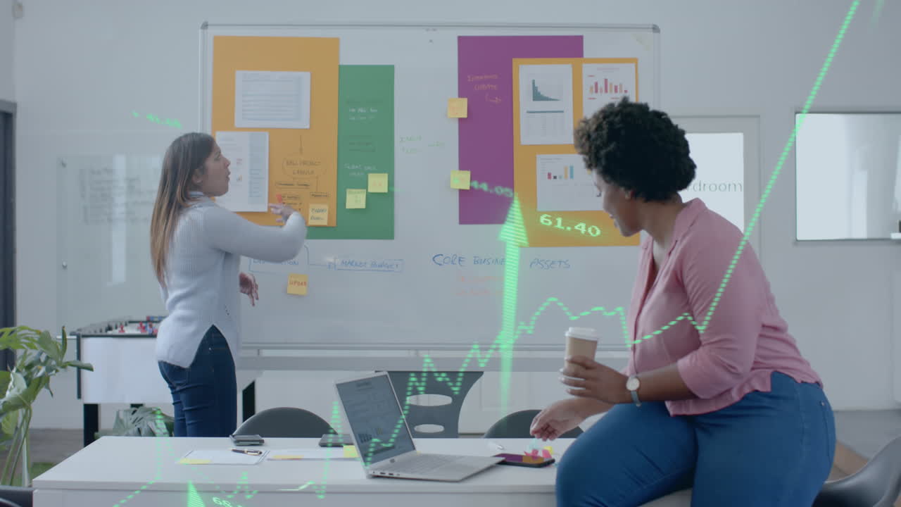 Green graph and up arrows over diverse female colleagues brainstorming at casual office meeting