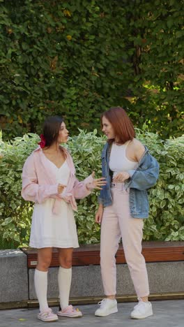 two young women having a conversation in a park