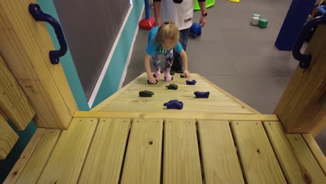 girl climbing on playset inside