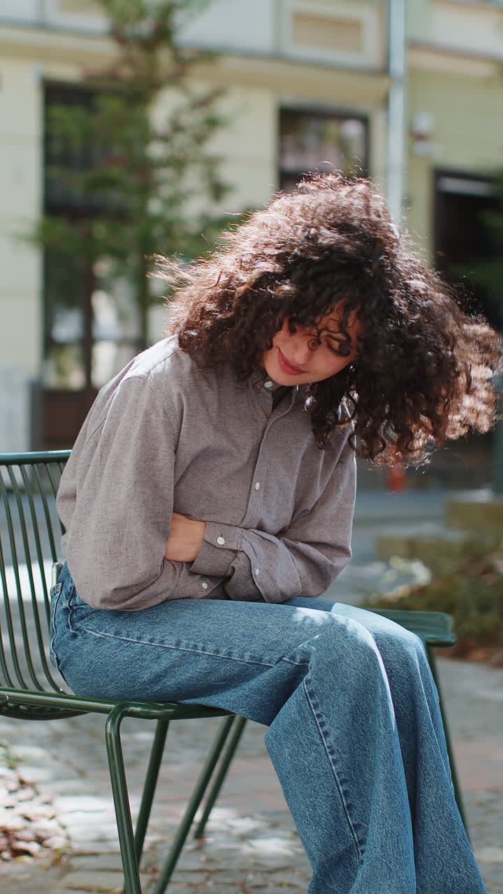 Sick ill woman girl suffering from period cramps stomach ache menstrual pain gastritis, city street