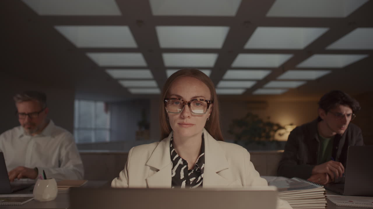 Confident Businesswoman Working on Laptop at Desk in Modern Office Space